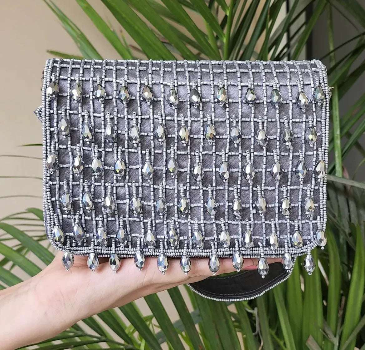 Grey bohemian clutch bag with cutdana detailing and droplets, perfect for adding glamour to any outfit.