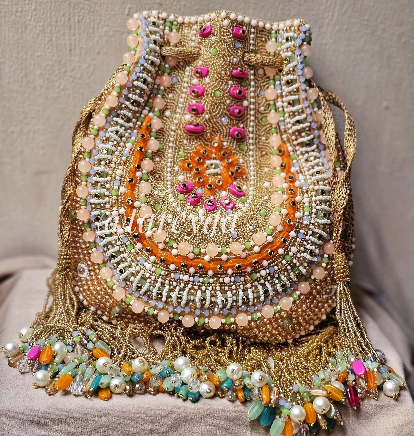Handmade Qavali Potli in emerald and multi-color beadwork with cutdana embellishments and drawstring closure.