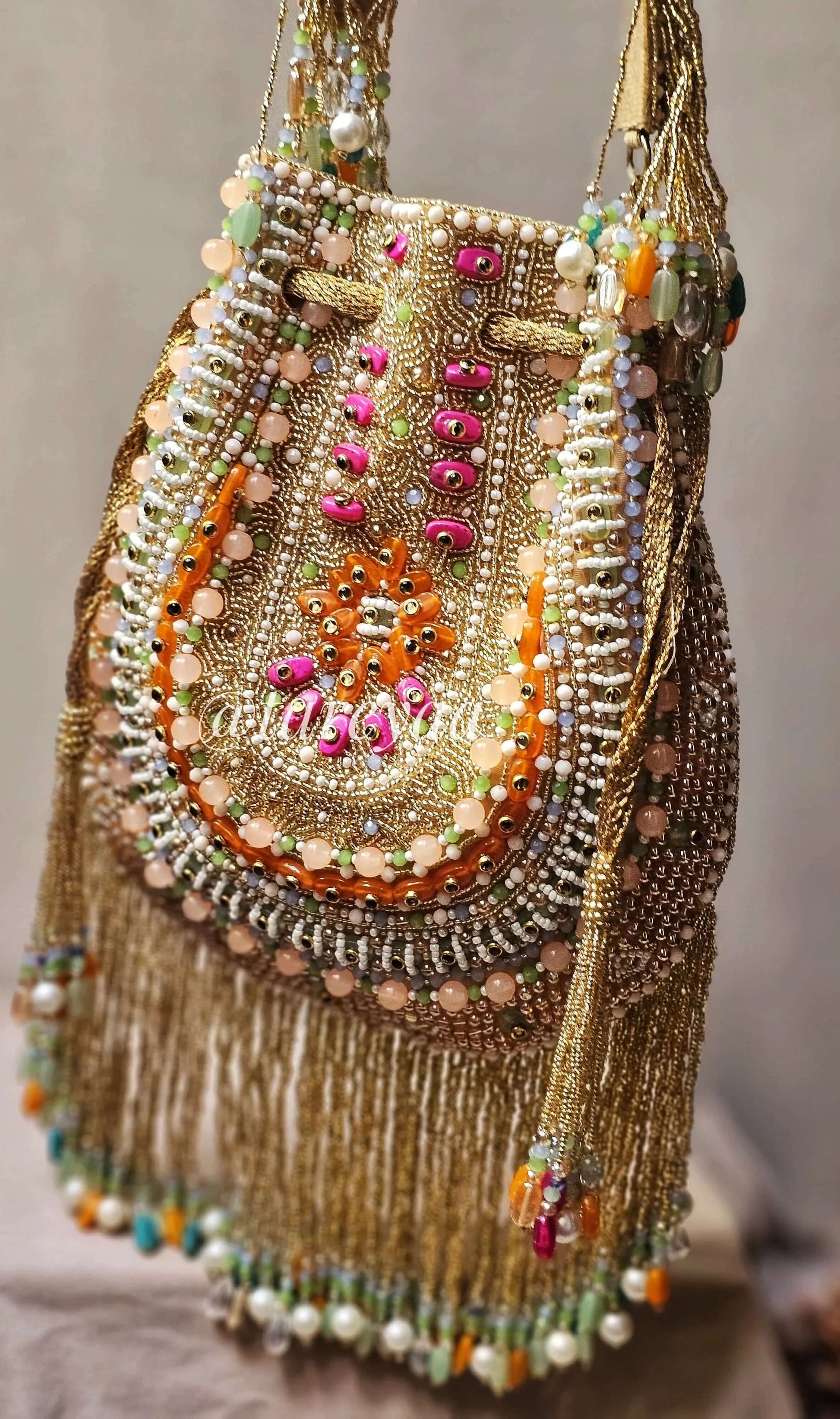 Handmade Qavali Potli in emerald with intricate beadwork and golden cutdana embellishments, perfect for any occasion.