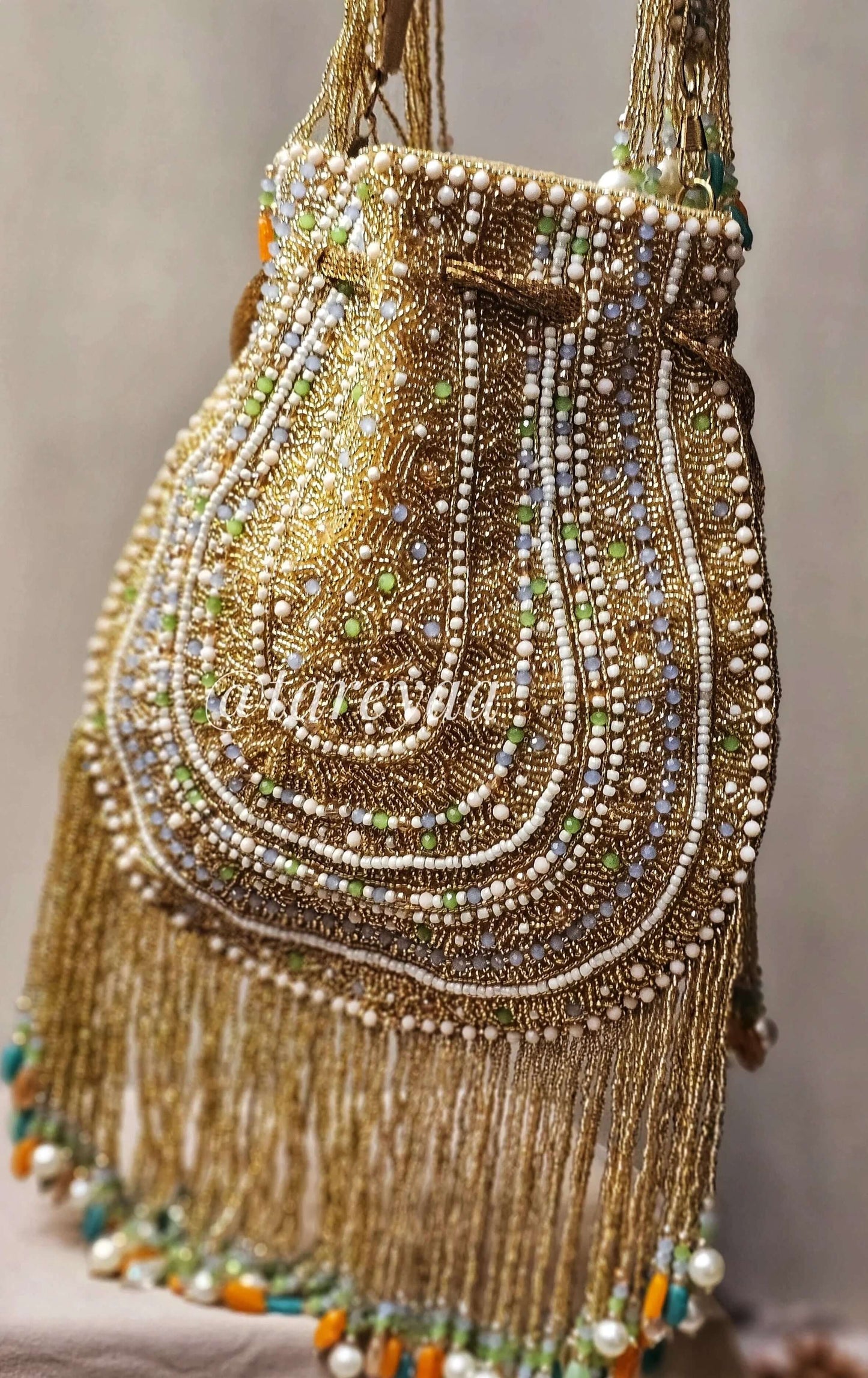 Handmade Qavali potli in emerald with intricate beadwork and golden cutdana embellishments, featuring a drawstring closure.