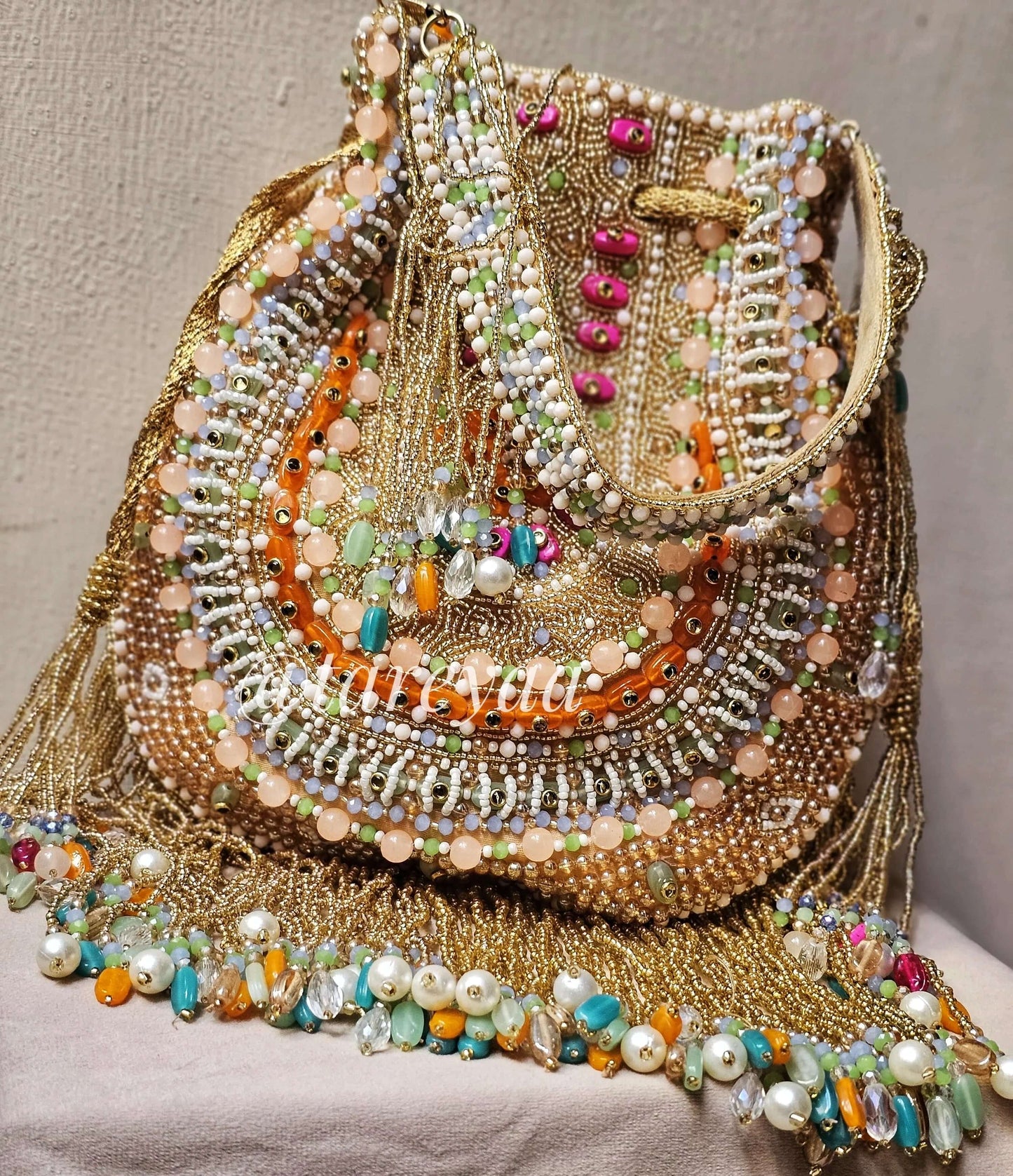 Handmade Qavali Potli in emerald hues with intricate beadwork and golden embellishments, perfect for adding elegance to any outfit.