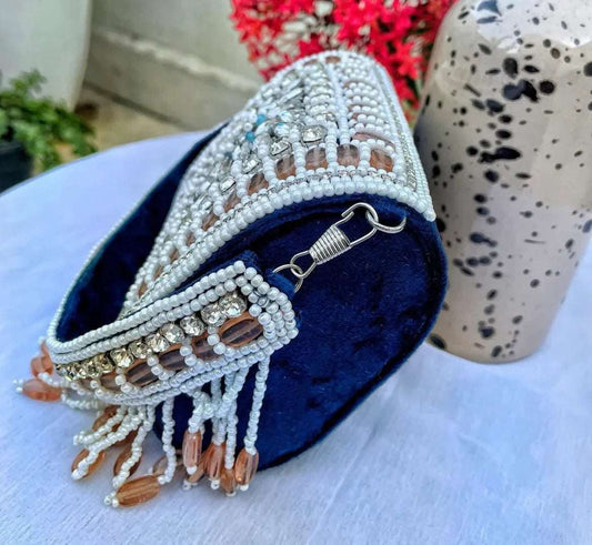 Embellished blue clutch bag with pearls, stones, and bead detailing, showcasing its unique bohemian design.